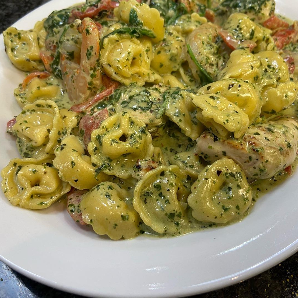 Michael G's tortellini pasta with chicken, red peppers, and spinach in a creamy pesto sauce.