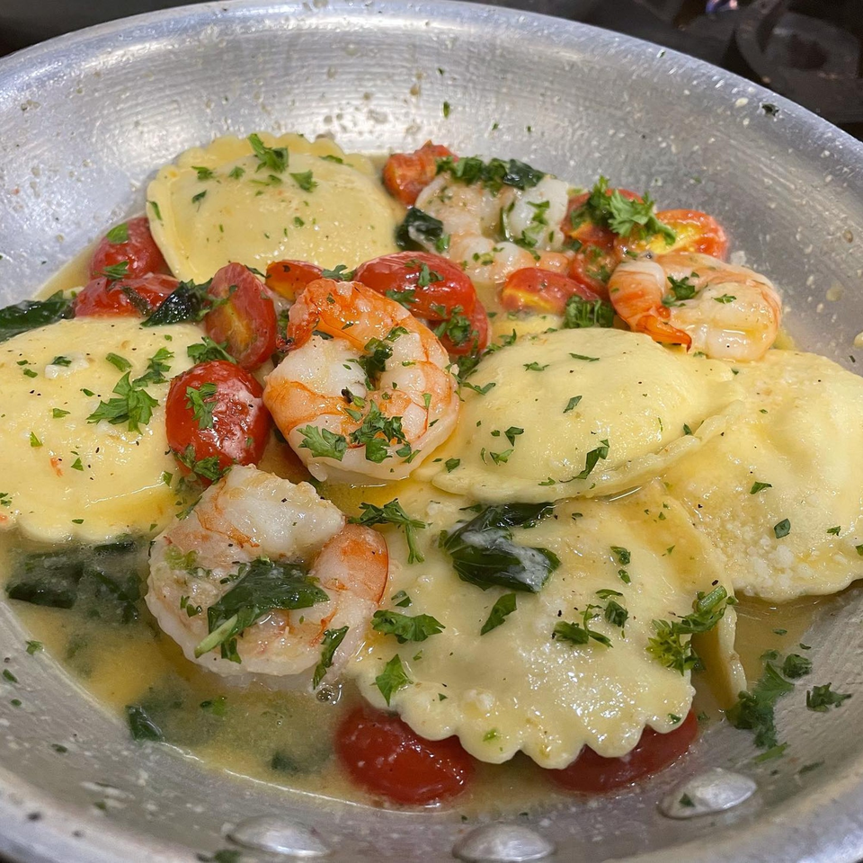 Michael G's ravioli with shrimp, cherry tomatoes, and parsley in a light sauce.