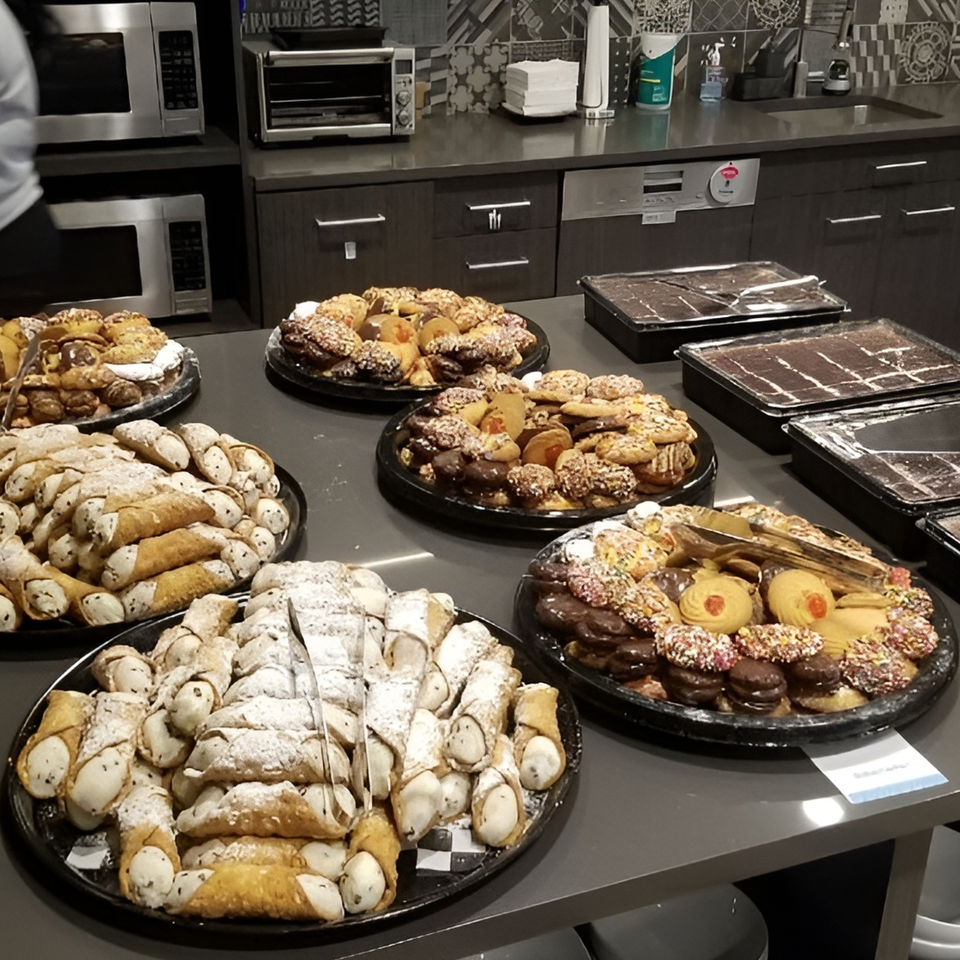 Trays of cannoli, Italian cookies, and brownies on a counter at Michael G's Handcrafted Italian.