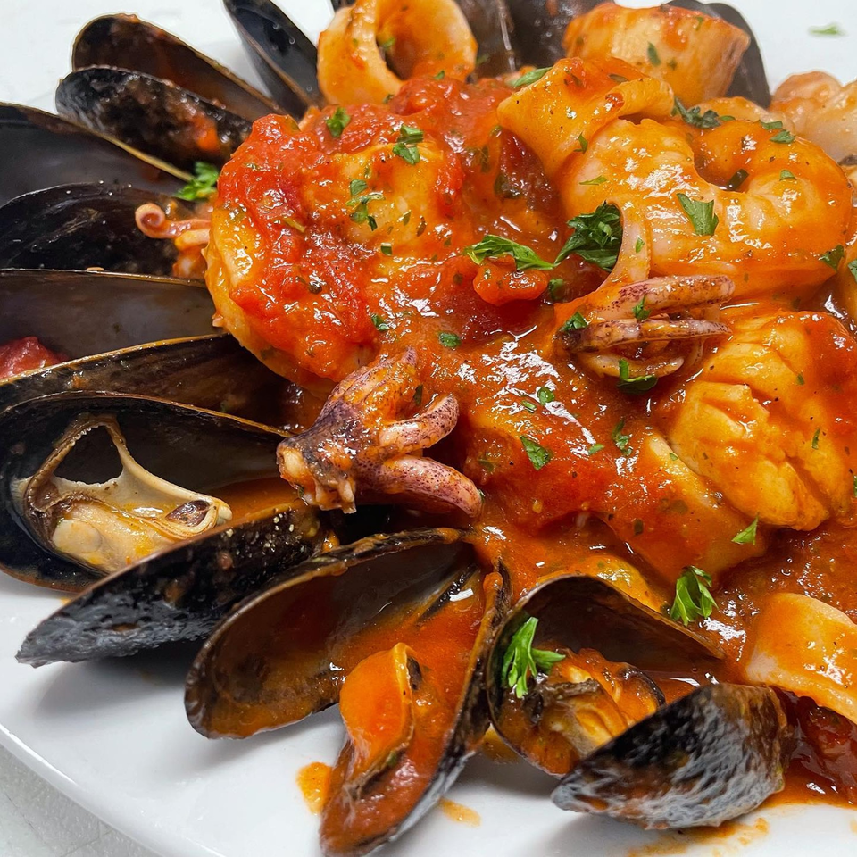 Michael G's Handcrafted Italian seafood dish with mussels, shrimp, and calamari in red sauce.